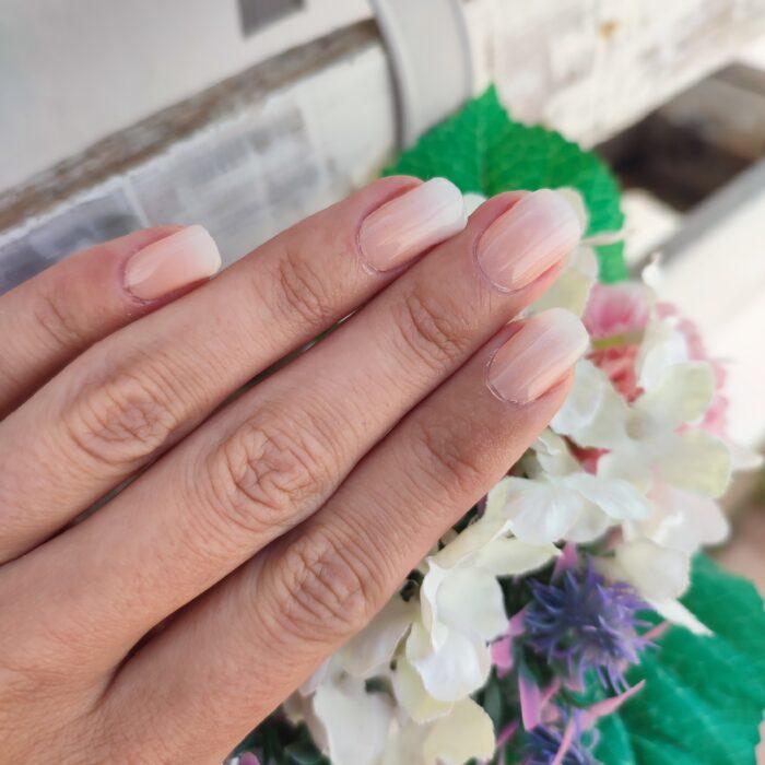 PEACH BABYBOOMER UV Gelnailz. Schöne Fingernägel mit Blumen im Hintergrund