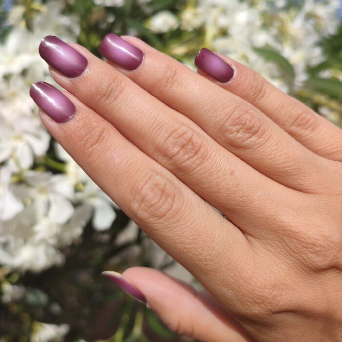 VIOLET VOUGE UV Gelnailz. Gepflegte Fingernägel über weißen Blumen