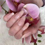 BABY pink UV Gelnailz. Eine Nagelfolie in zartem Pink verschönert Lange Fingernägel, die eine Orchideenblüte umschliessen