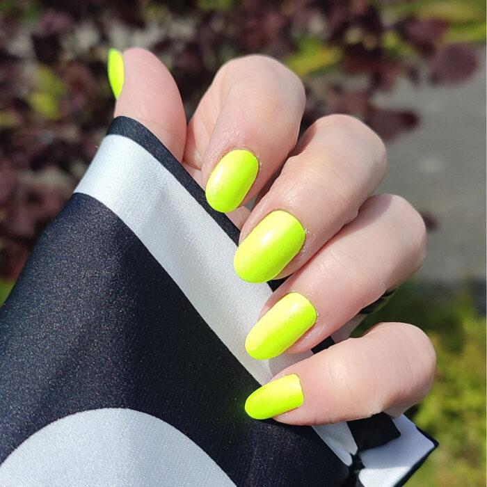 Schöne lange Nägel mit der Nagelfolie GREEN neon Nailz im Sonnenschein.