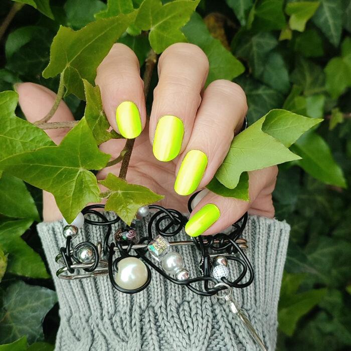 Tragefoto der Nagelfolie GREEN neon Nailz mit schöner Brosche in der Hand