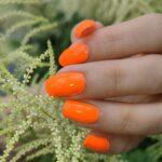 Tragefoto der leuchtenden ORANGE neon Nailz bei Tageslicht.