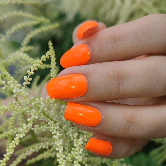 Tragefoto der leuchtenden ORANGE neon Nailz bei Tageslicht.