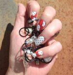 Hand mit COMIC CHIC Nailz und Schmuck festhaltend