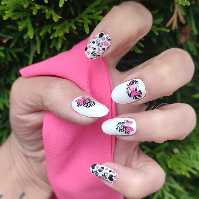 Hand mit MINNIE CRUSH Nailz und rosa farbigem Tuch in der Hand