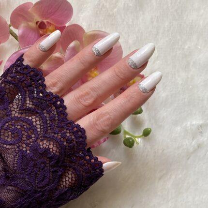 Nagelfolie WHITE LUXE glitter Nailz auf schönen langen Nägeln vor einem hellem Hintergrund.